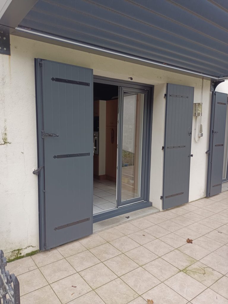 Porte-fenêtre avec volets battants gris installée à Roanne par Pro Isol’ Menuiserie