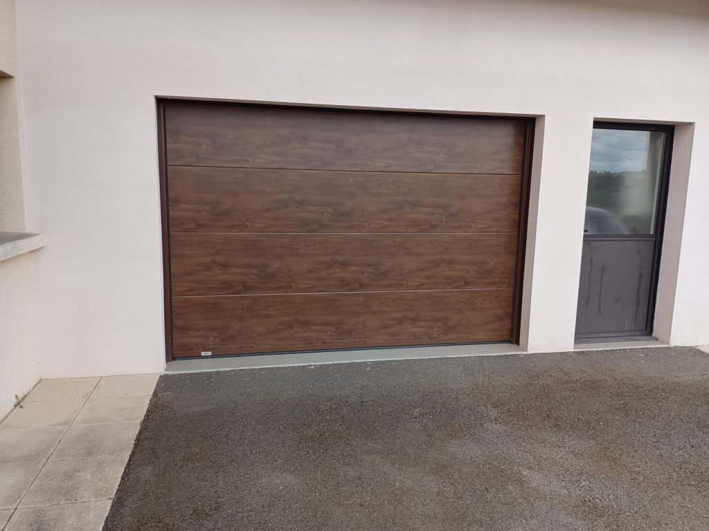 Porte de garage sectionnelle aspect bois brun à panneaux horizontaux, intégrée à une façade claire.