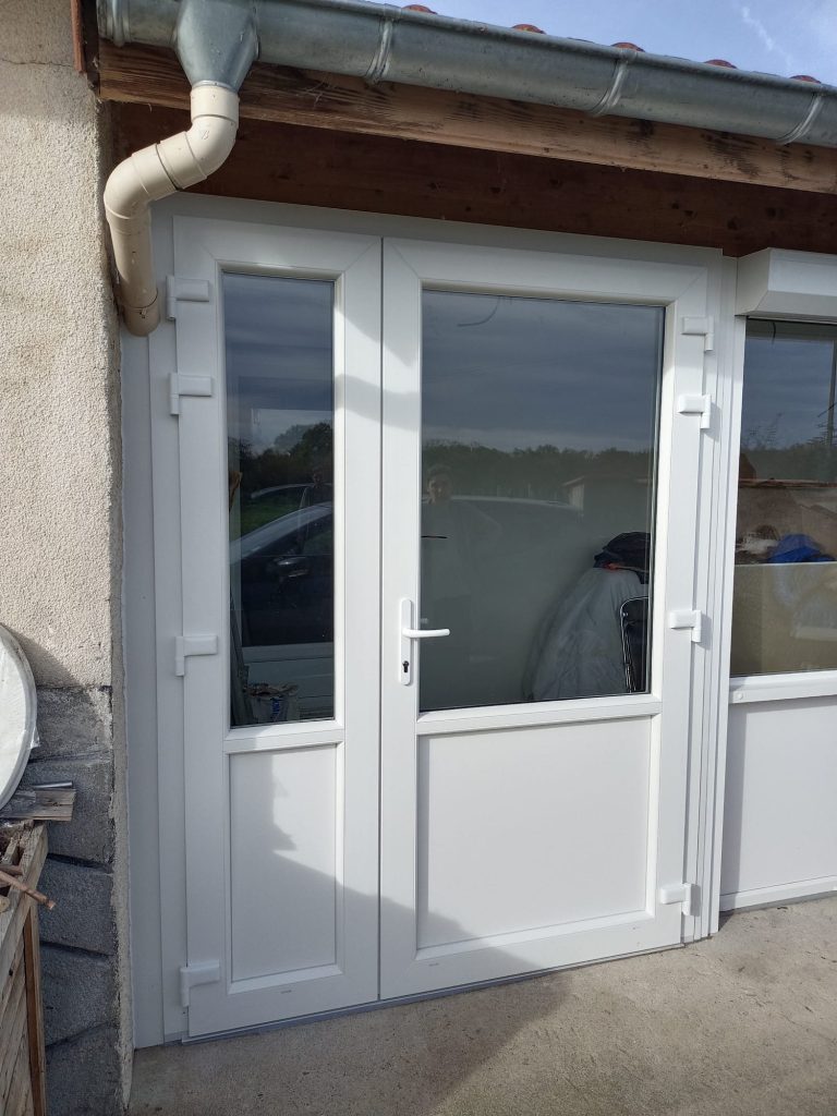 Porte blanche semi-vitrée à deux vantaux inégaux, avec soubassements pleins et poignée blanche.